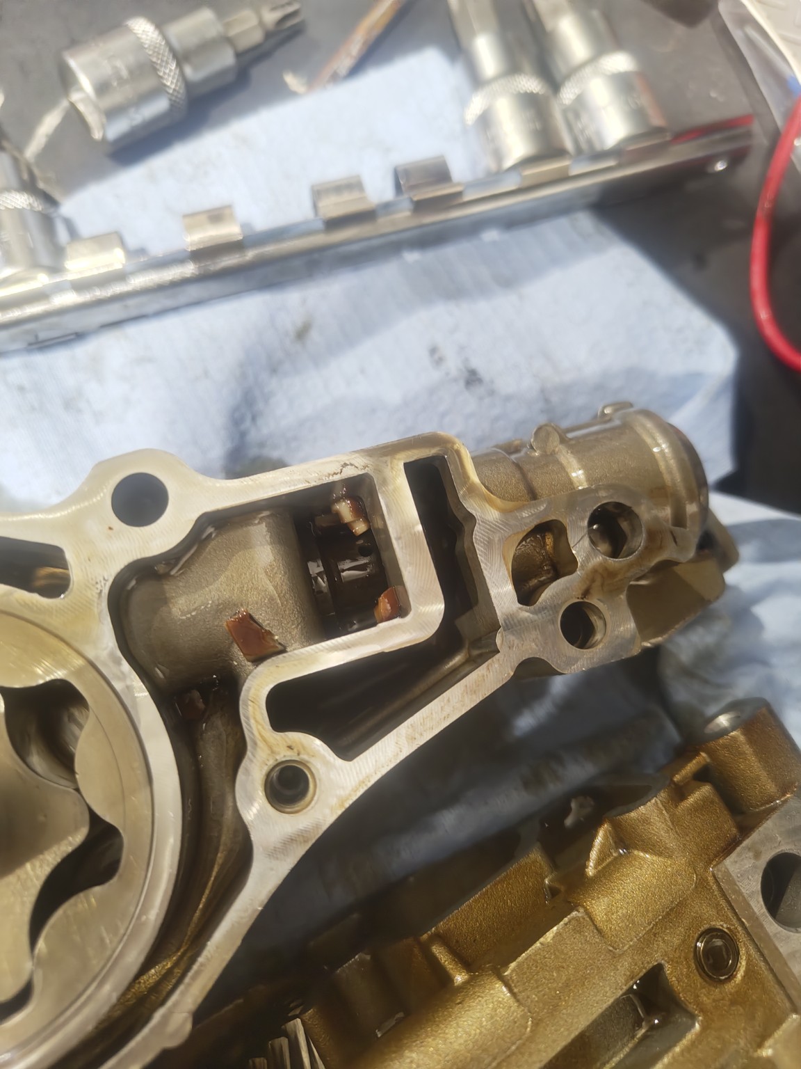 Plastic fragment from broken chain guide stuck in BMW N46 oil pump pressure relief valve area
